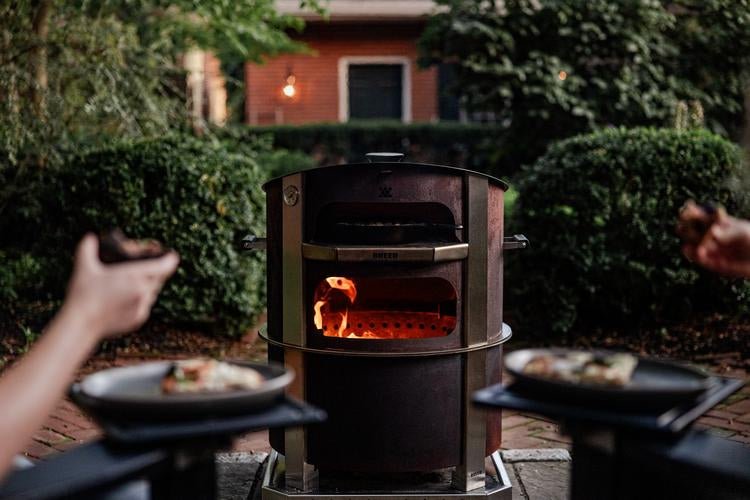 This is an image of the Breeo Live-Fire Pizza Oven on an X24 Firepit