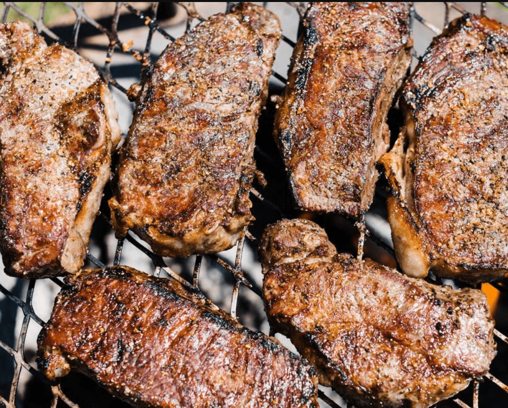 Steaks grilled over the fire with a Breeo Outpost Grill