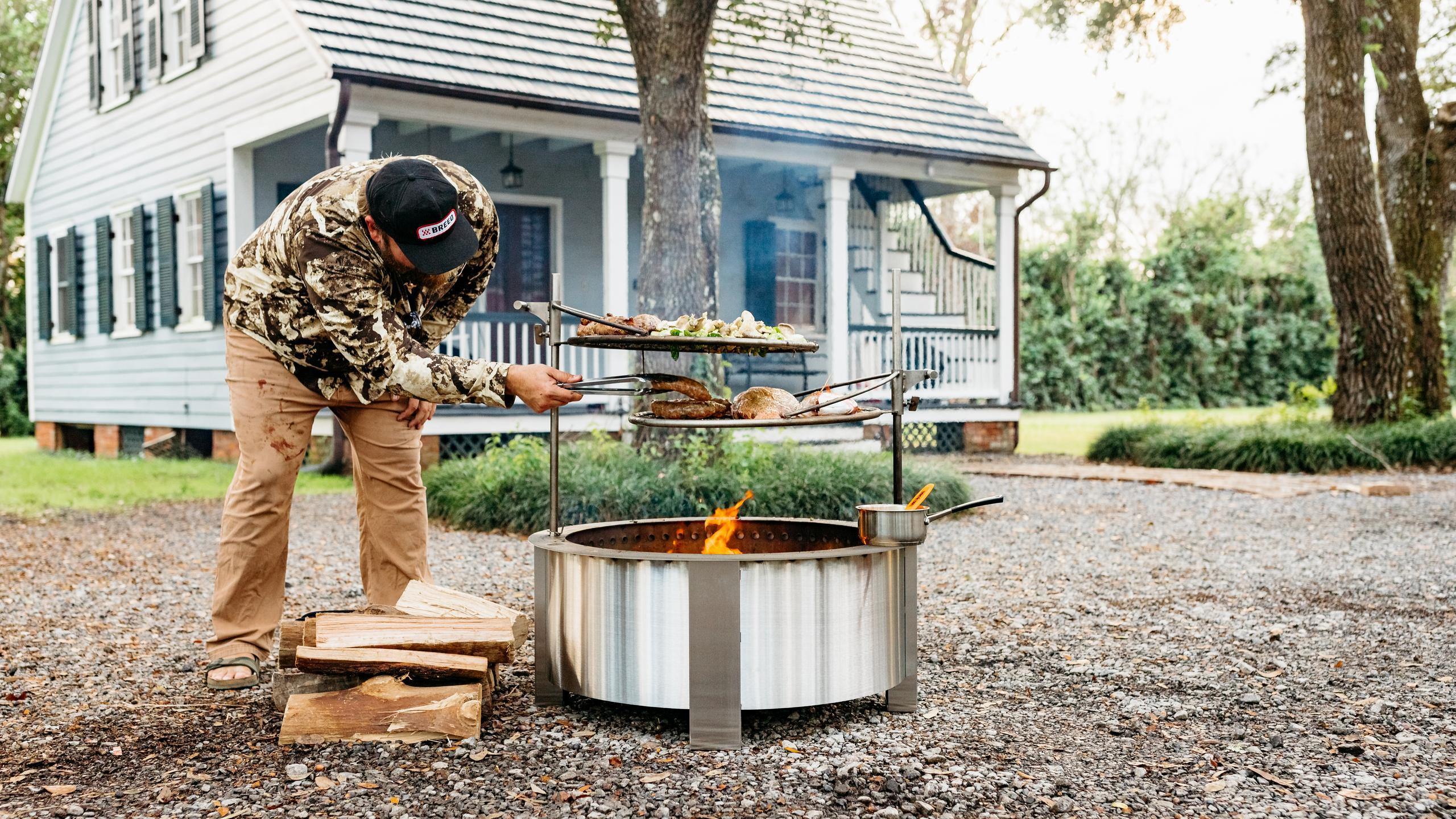 This is an image of Chef Jean-Paul grilling on the X30 firepit with Outpost Grills attached
