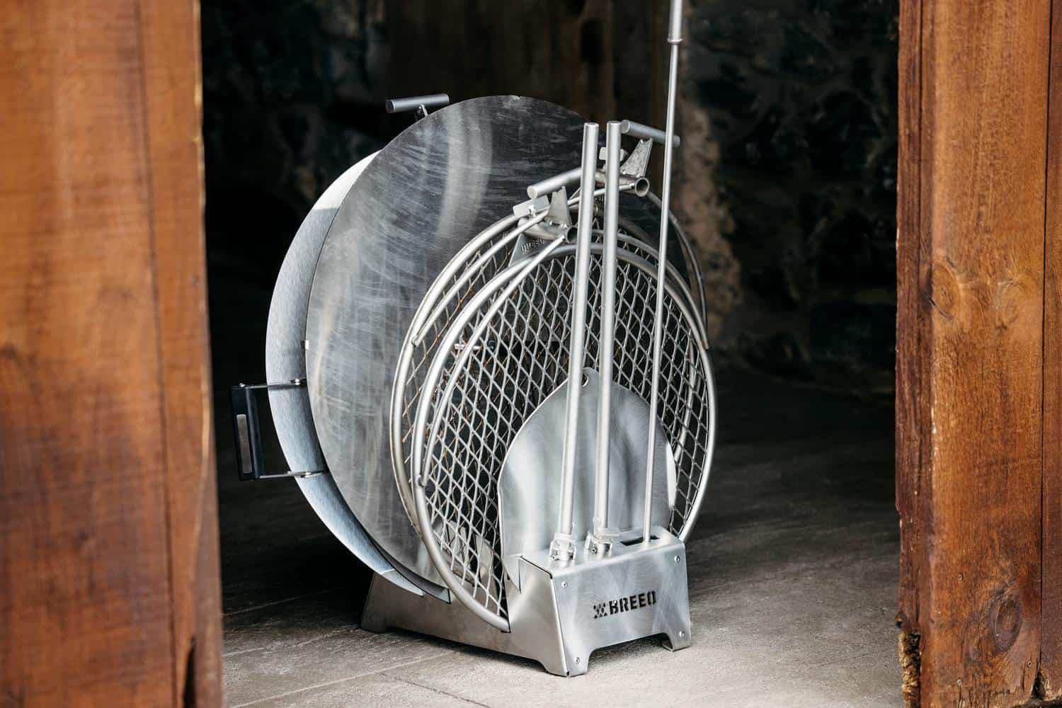 This image of the Breeo Accessory Dock includes the following accessories: Firepit Lid, Heat Deflector, Two outpost grills, Sear Disc, and Fire Poker