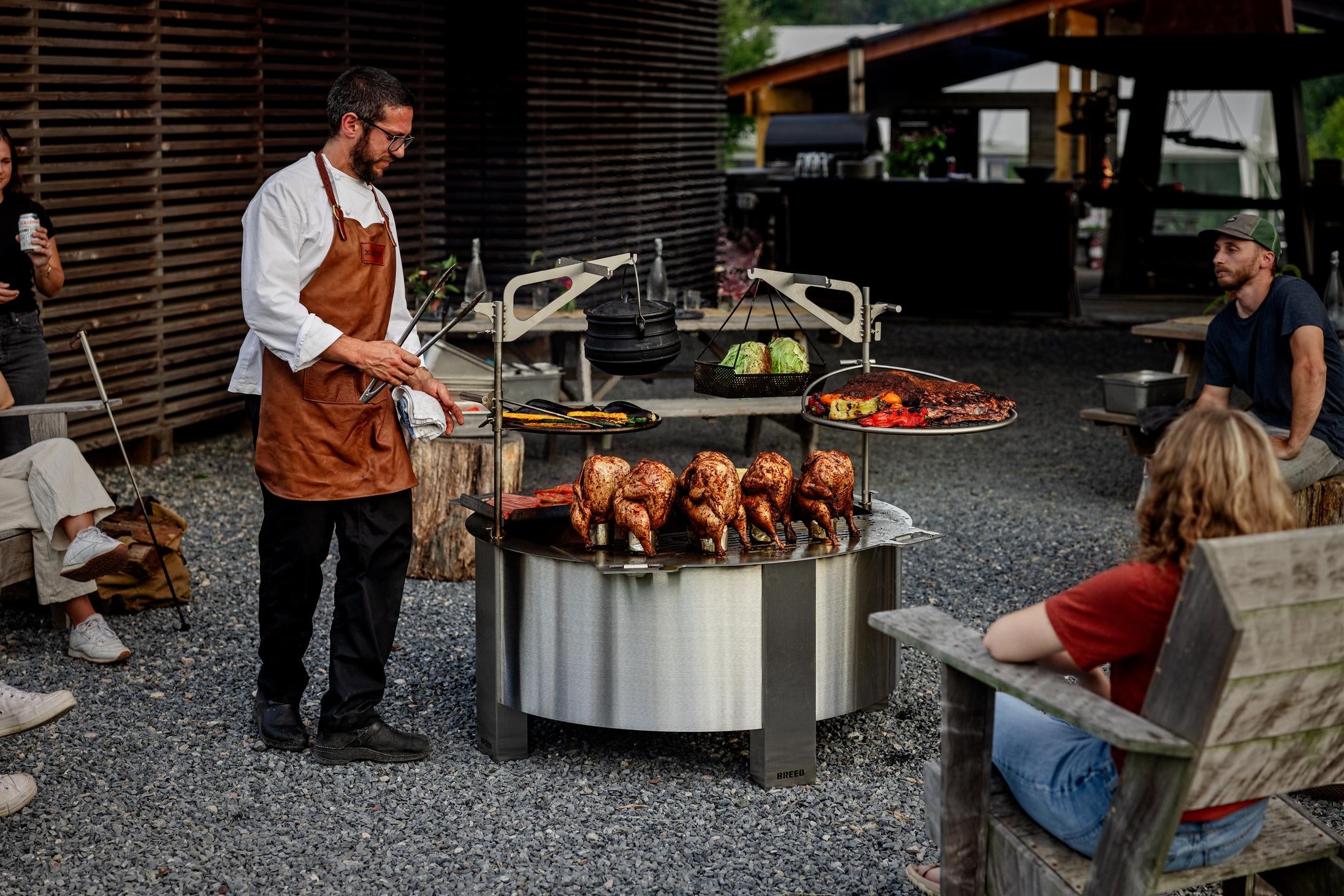 A chef grilling on an X42 firepit with grilling attachments