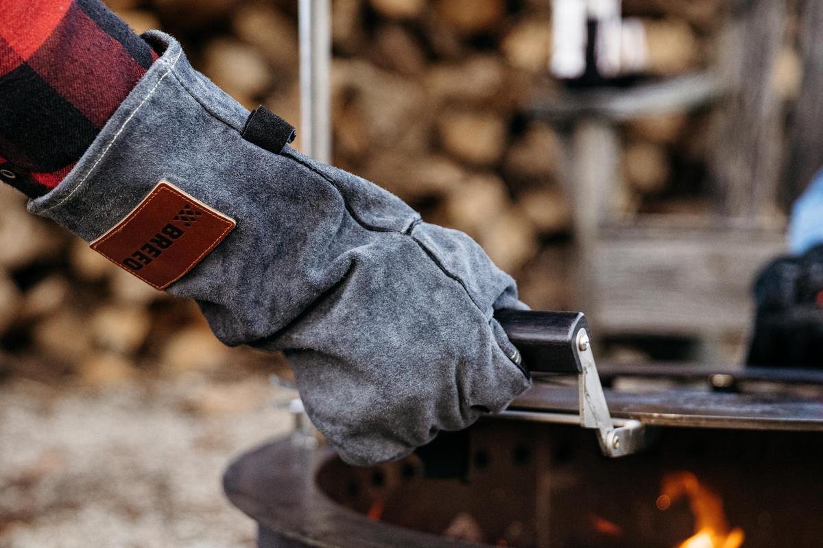 This is an image of a person using the Breeo Leather Fire Gloves