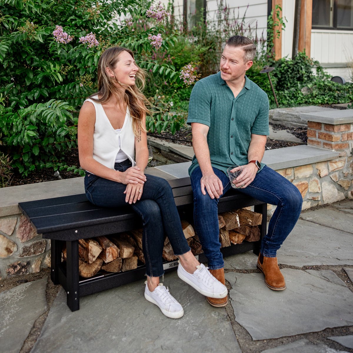 Two people laughing and enjoying the evening while sitting on a Breeo X Series Bench