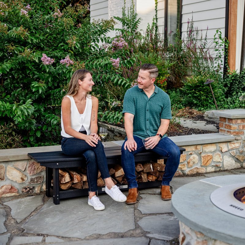 Two people sitting on a Breeo X Series Bench while sipping wine next to a Zentro fire pit