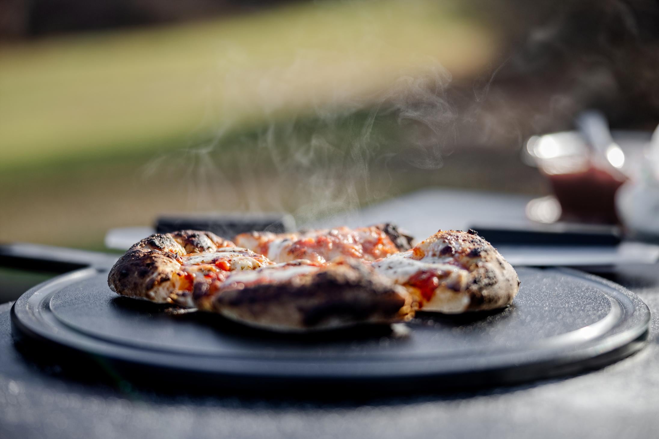 This is an image of fresh baked pizza served on thethe Breeo Serving Board