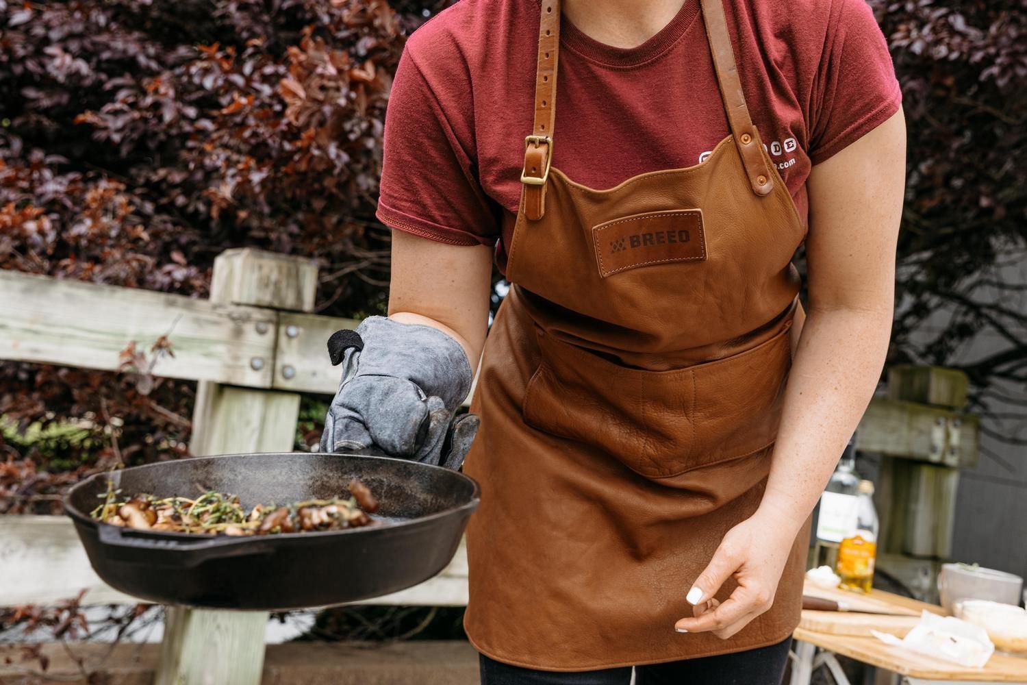 This is an image of a person wearing Breeo Leather Grilling Apron