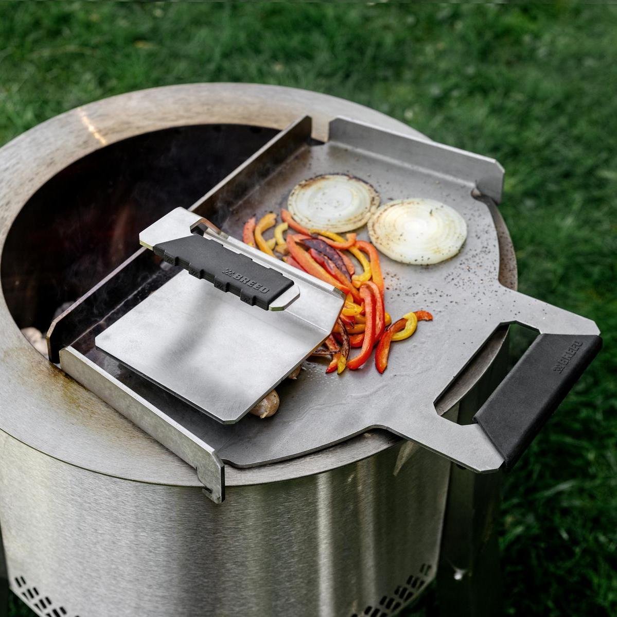 This is an image of sausage grillers being grilled on a Breeo Flat Top with the Breeo Griddle Press