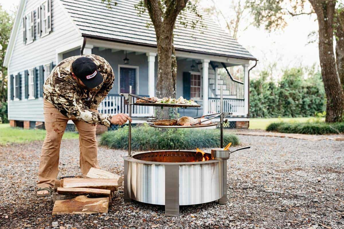 A man grilling on an X30 Stainless in front of a house