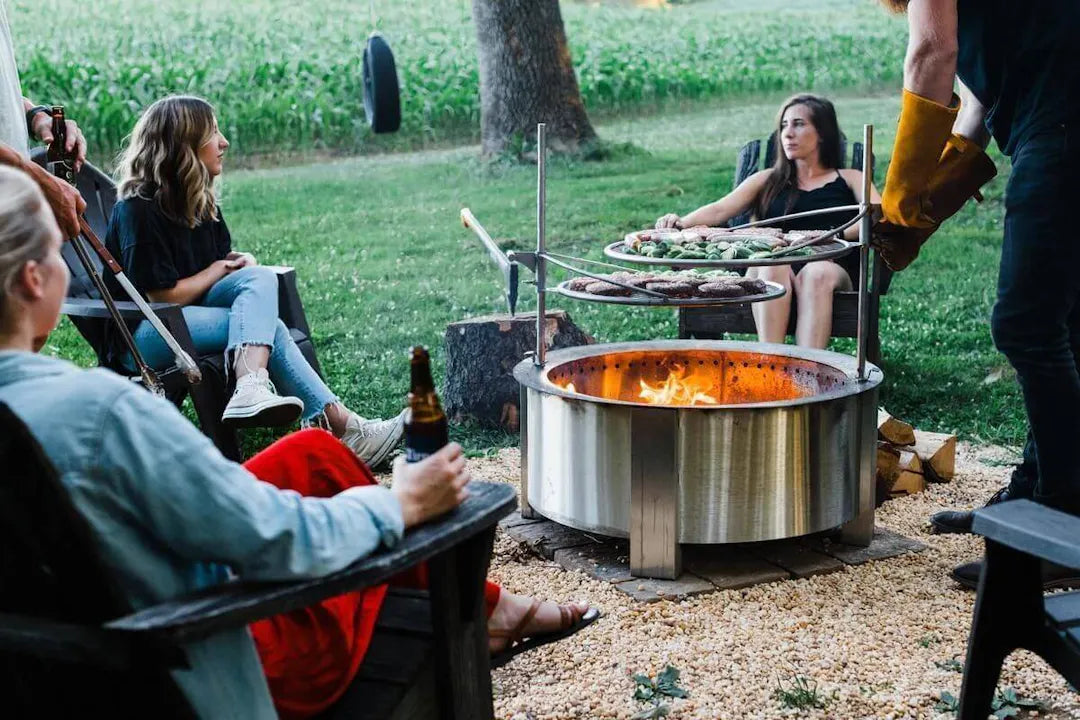 A group of friends grilling burgers on a Breeo X Series 30 in stainless steel