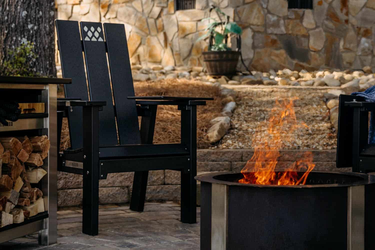 This is an image of the Black X Series chair next to a Breeo Firepit