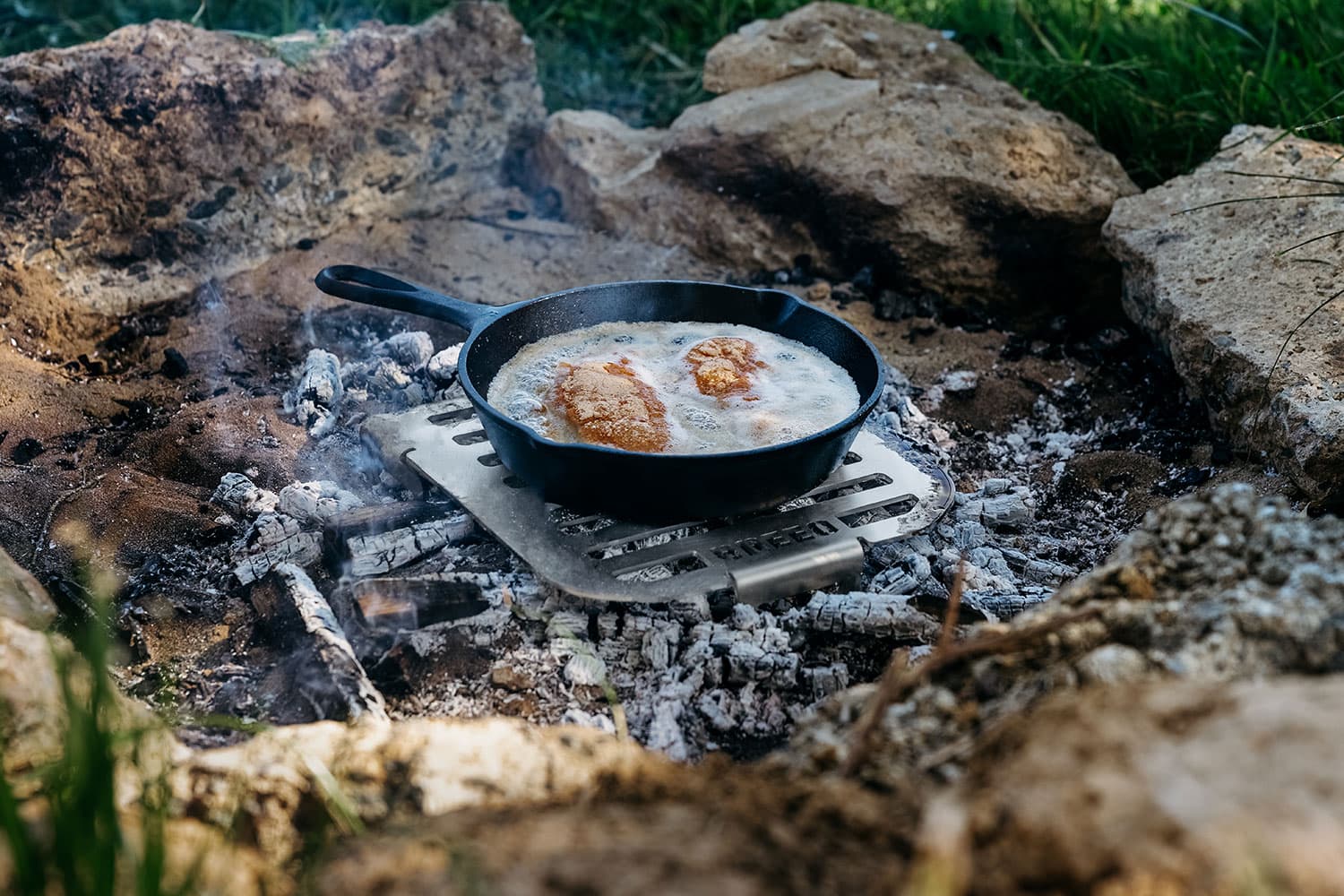A Breeo Skillet Rest over a bed of hot coals used to fry chicken.