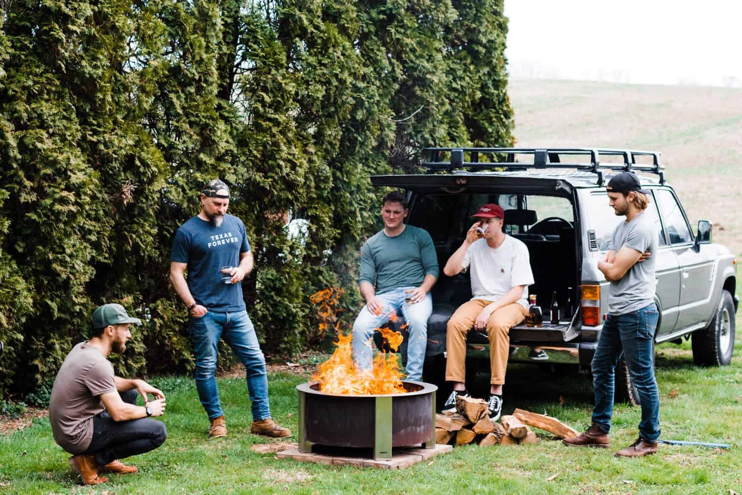 X30 Corten firepit with a group of guys having a tailgate party
