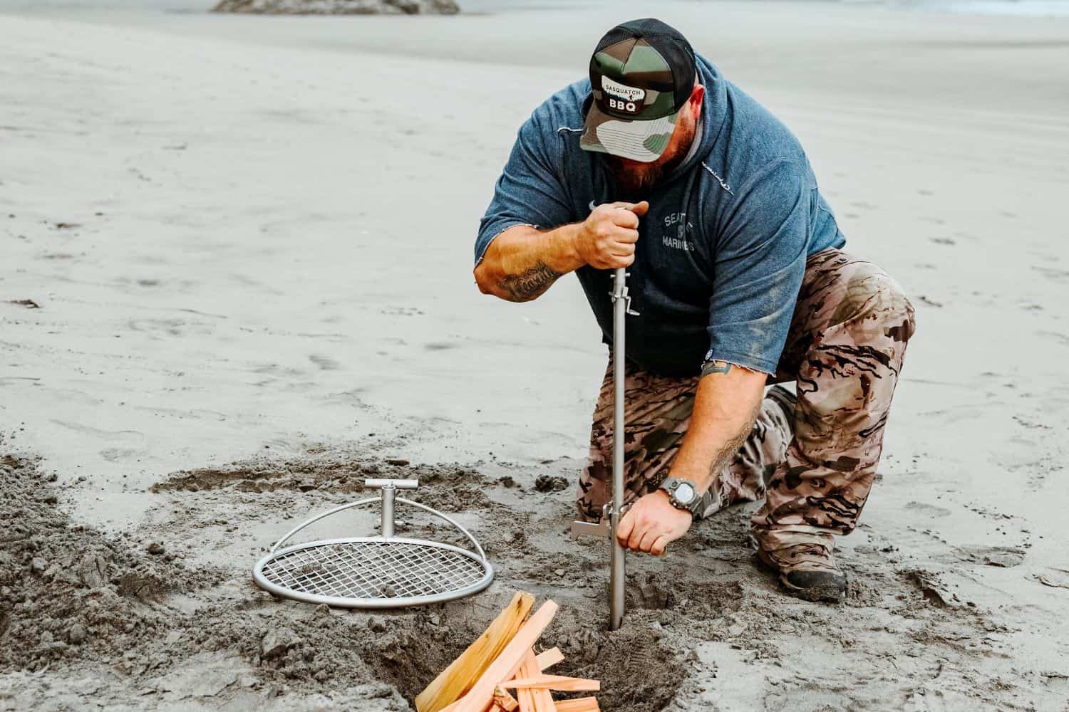 A man staking an Outpost rod into the ground