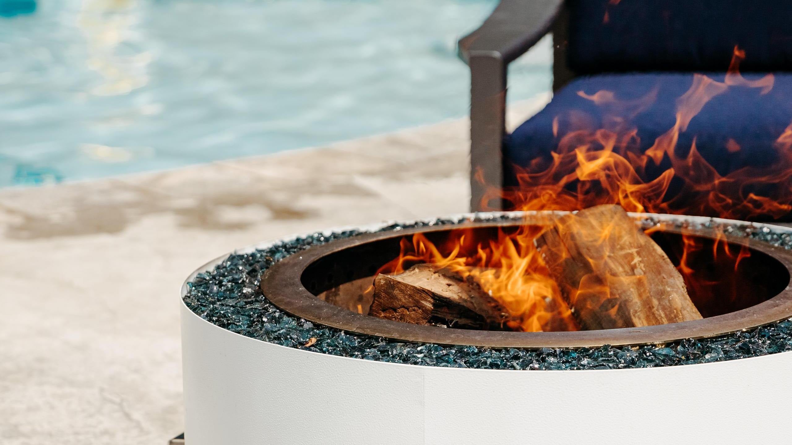 Luxeve firepit burning near a pool 