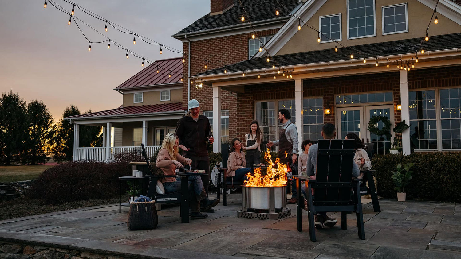 This is an image of friends and family hanging out in the backyard with a Breeo X Series Firepit and X Series Chair