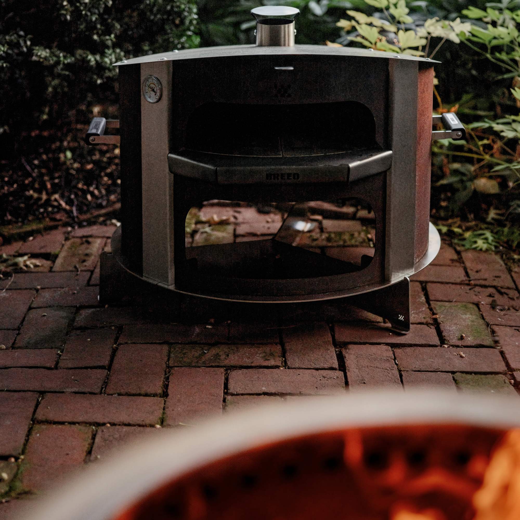 This is an image of a Breeo Corten Pizza Oven resting on a Pizza Oven Base 