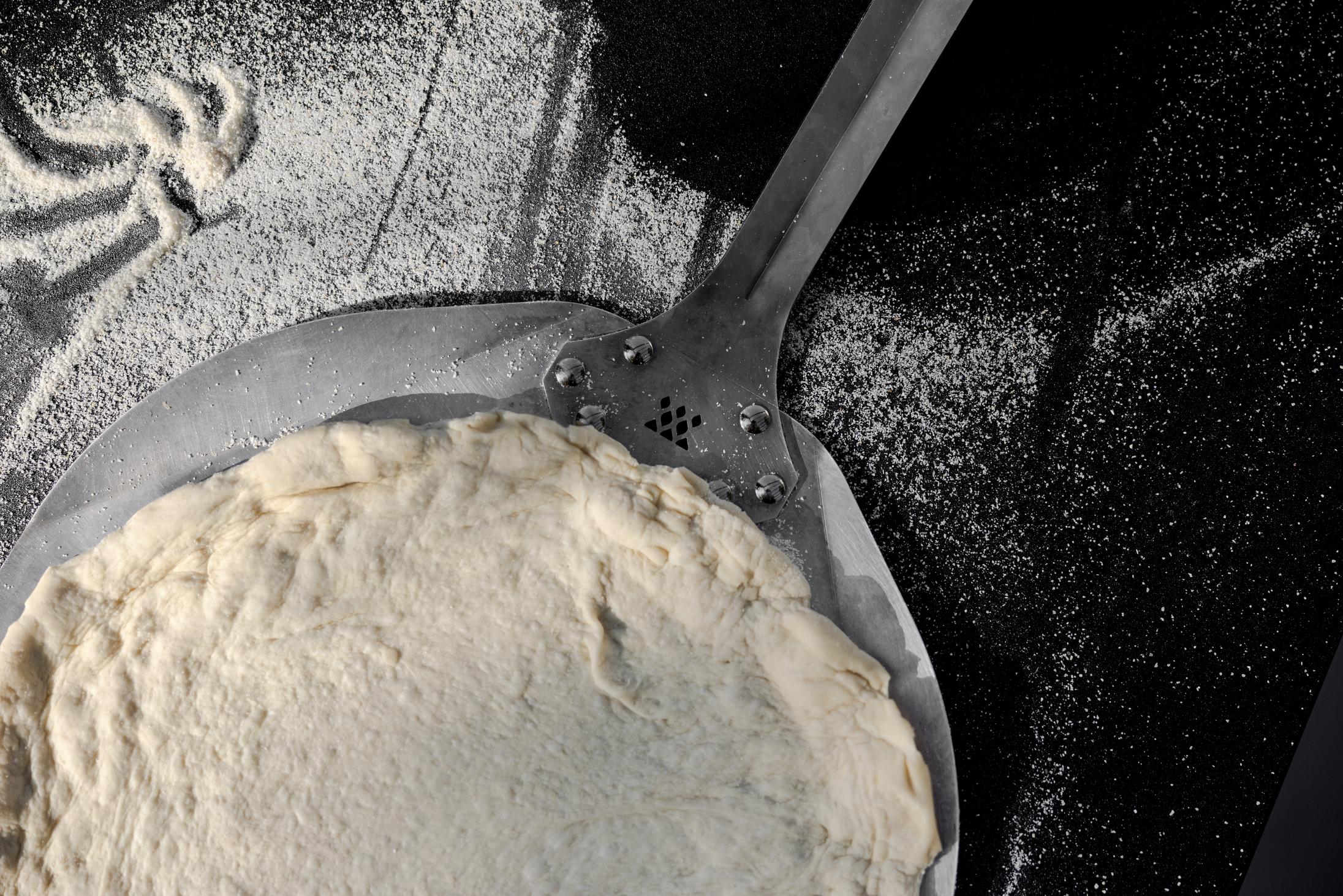 This is an image of pizza dough on a Pizza Peel
