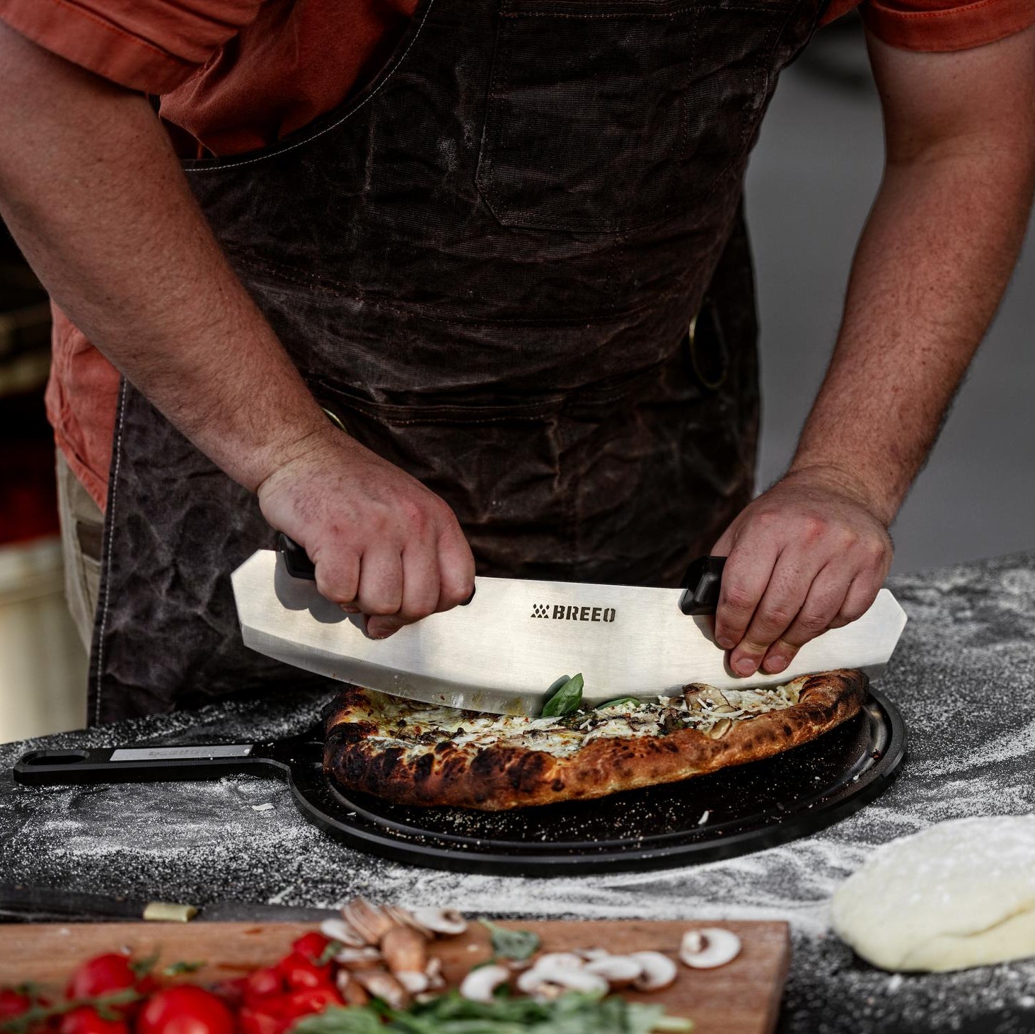 This is an image of someone using the Rocker to slice a pizza on the Serving Board. 