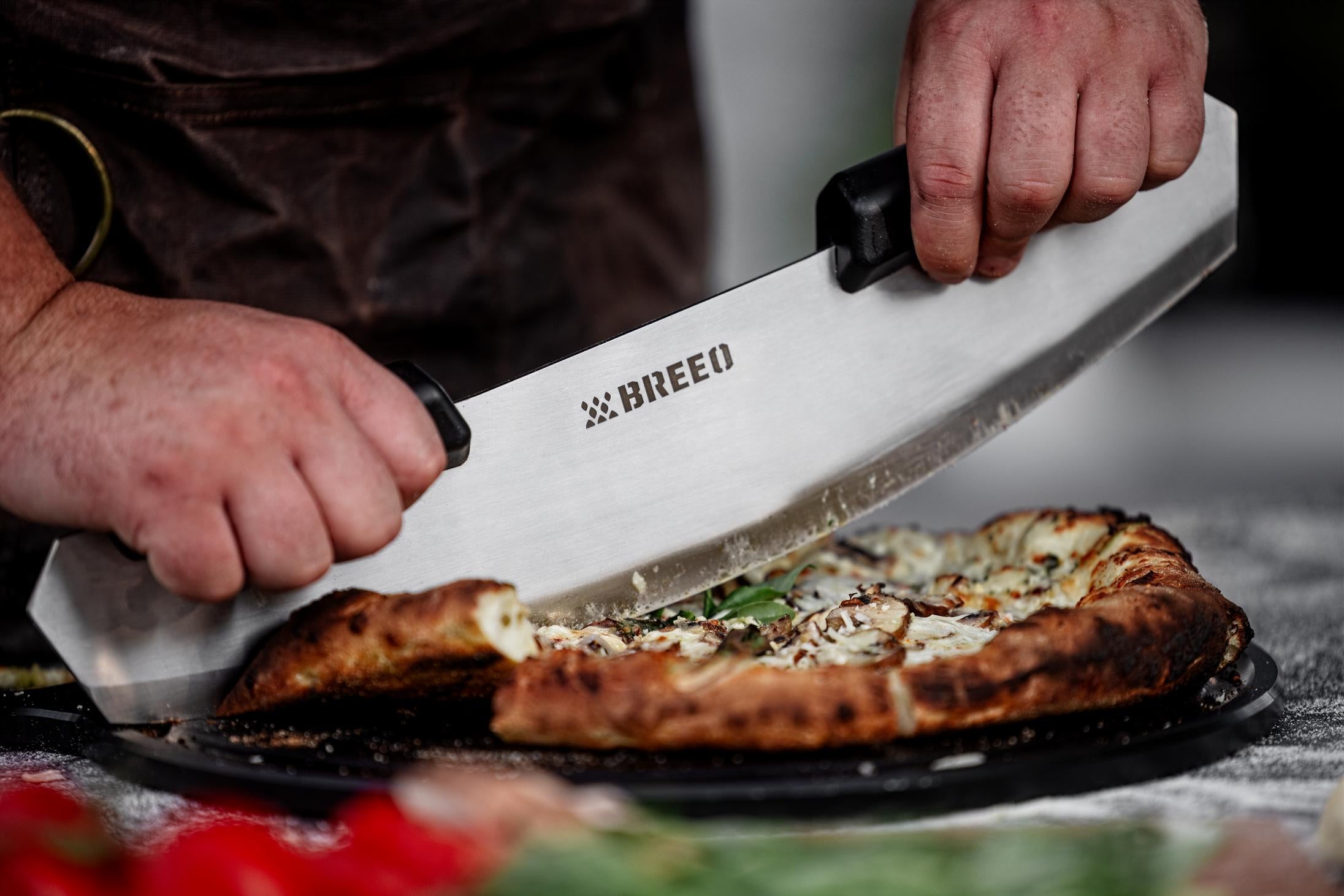 This is an image of the Breeo Pizza Rocker used to slice a pizza 