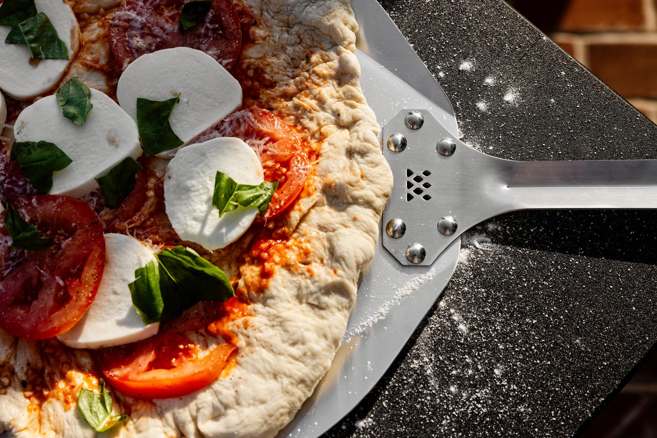 This is an image of Pizza on a  Breeo Pizza Peel