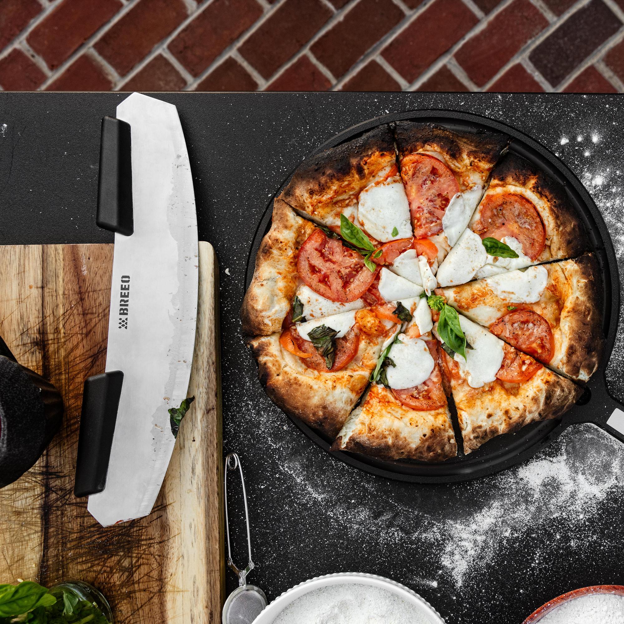 This is an image of the Breeo Pizza Rocker next to a fresh baked pizza on the Breeo Serving Board