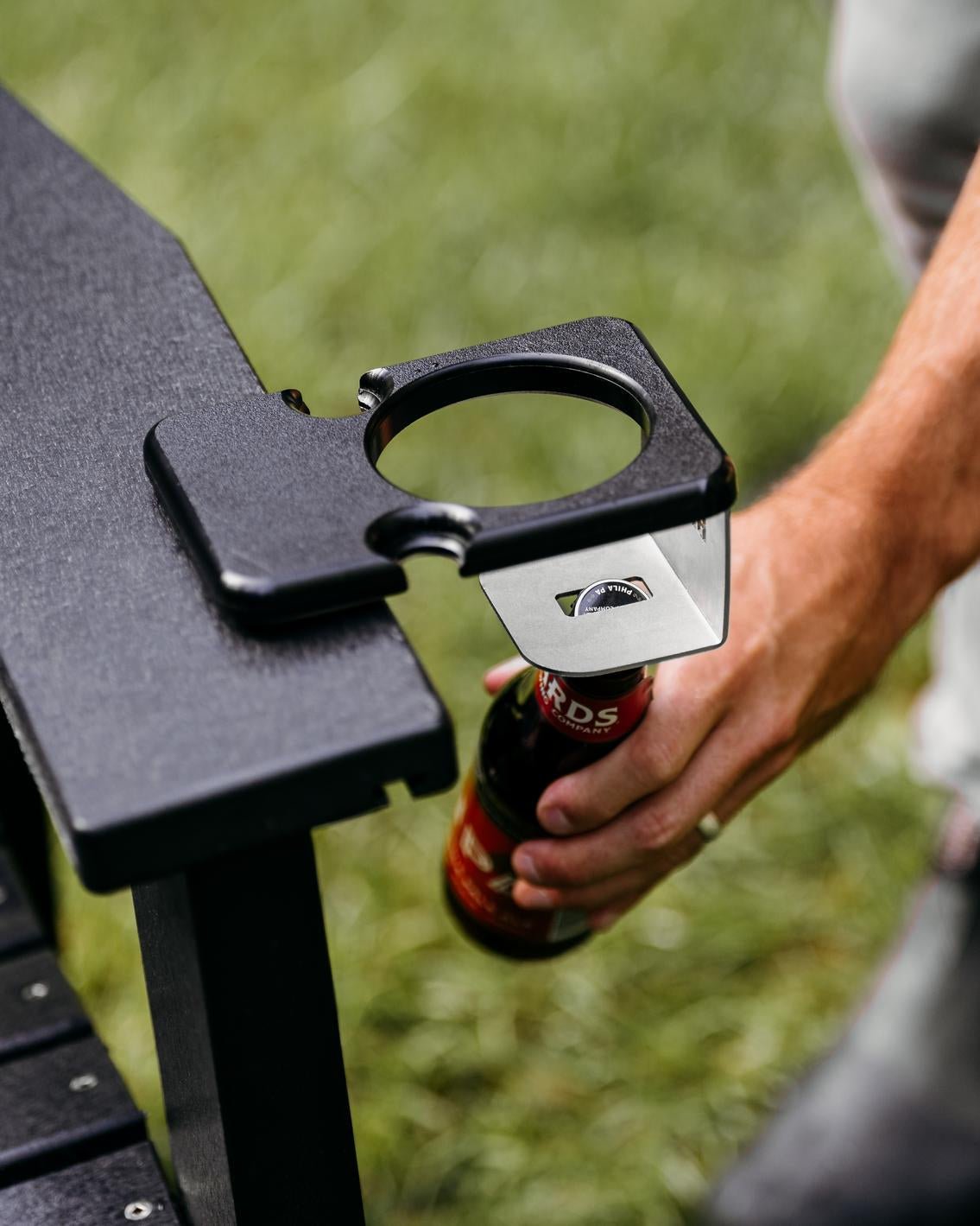 An image of a person opening a bottle using the Outrig cupholder