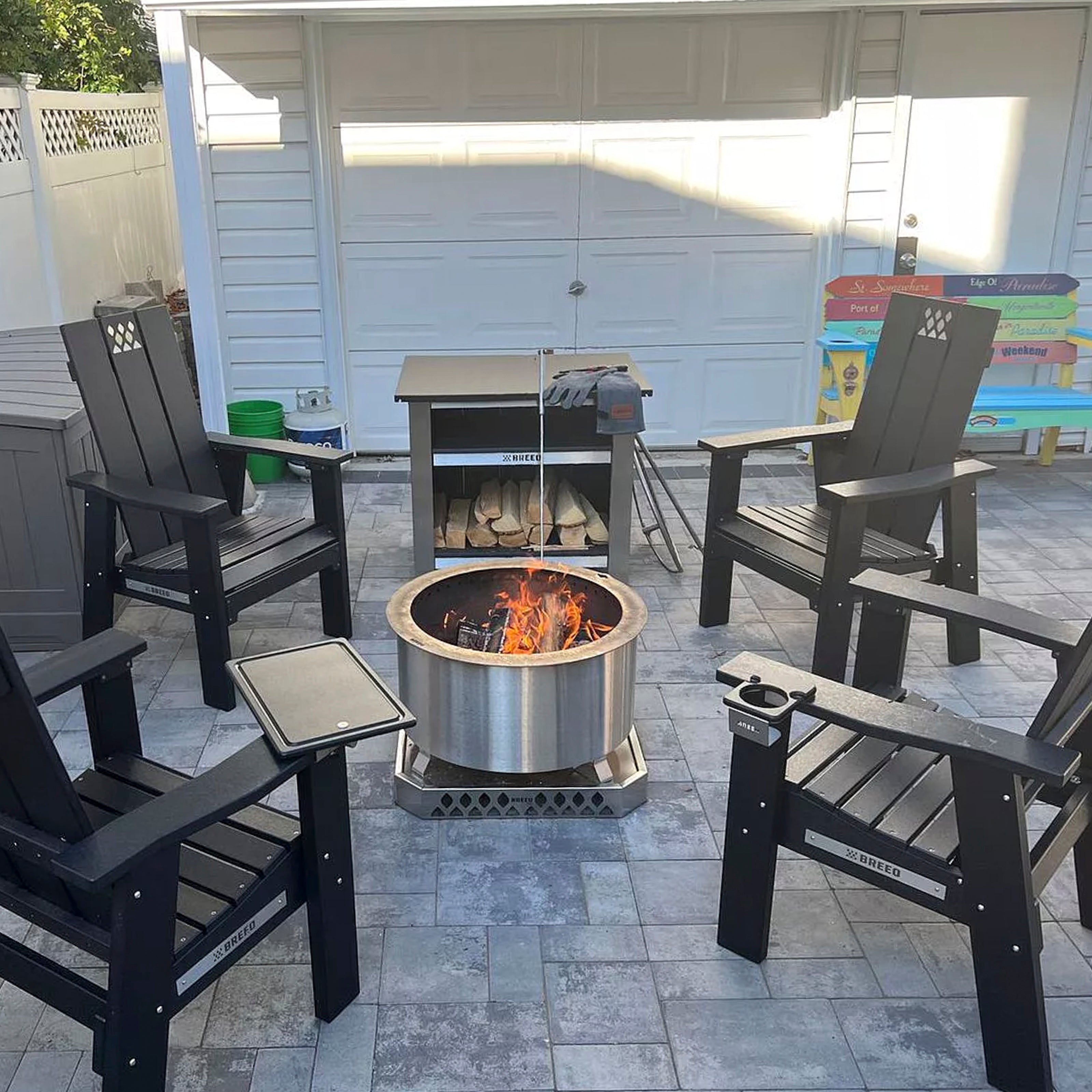 Outdoor patio with x series fire pit, x series chairs, and a x series grill on a tiled floor.